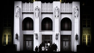 The front façade of Central High with animated figures of the Nine during a 3D video program in 2017
