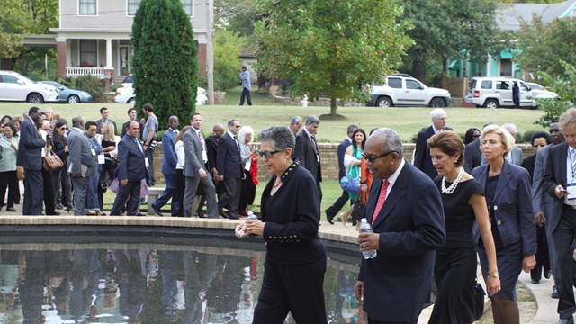 Photo of several members of the Little Rock Nine leading a group around the reflecting pool.