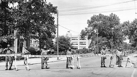 Soldiers stand behind barricades in front of Central High School during the 1957 integration crisis.