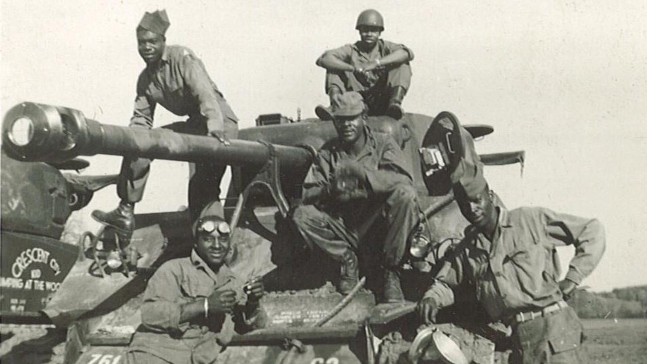 5 Members of the 761st Tank Battalion pose on their Sherman Tank during World War Two.