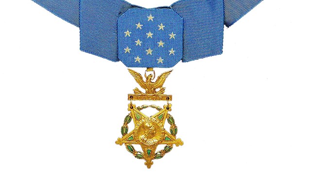 Color photograph of gold star medal hanging from blue ribbon necklace
