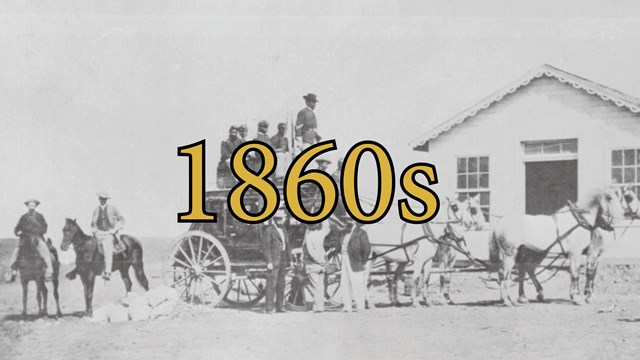 Black and white photo of numerous people standing in and on a stage coach.