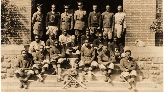 Image of18 are African American including: 6 in "C" sweaters; 8 wearing a gray button up jackets