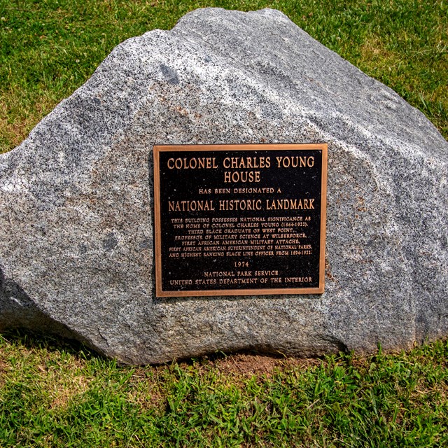 A large rock with a bronze plaque reading Colonel Charles Young House