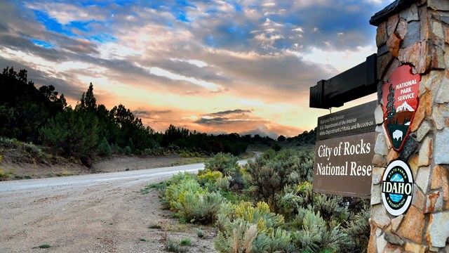 City of Rocks east entrance sign with dramatic sunset in the background.