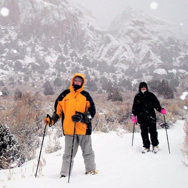 Two people snowshoeing during a snow storm in Castle Rocks