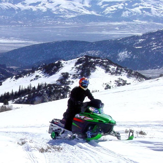 Person riding a snowmobile in the City of Rocks.