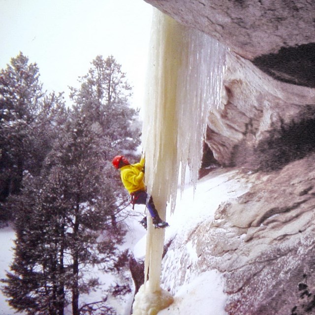 A person is climbing an ice structure.
