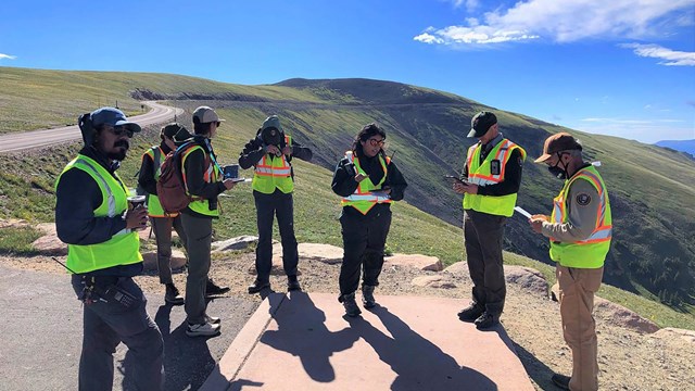 People stand in safety vests