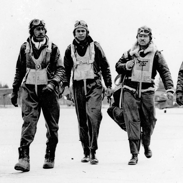 B&W; four WWII african american soldiers walk from airfield