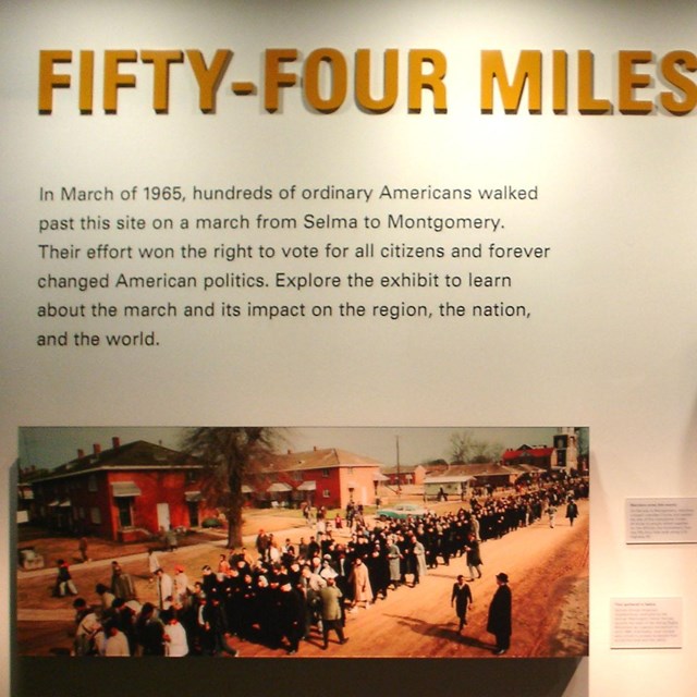 color photo of exhibit panel with title '54 miles to freedom' above 3 photographs