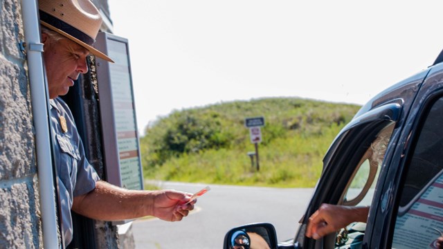 Visitor paying ranger at entrance station