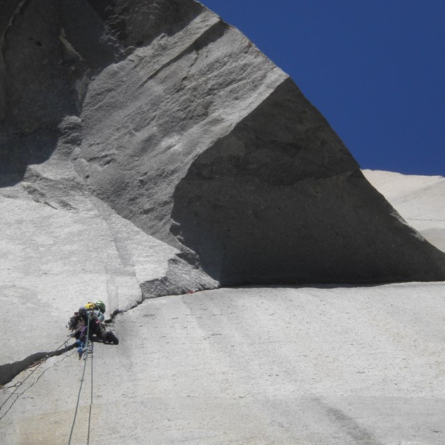 climber leading up under the great roof, a triangle overhang of granite, in Yosemite National Park 
