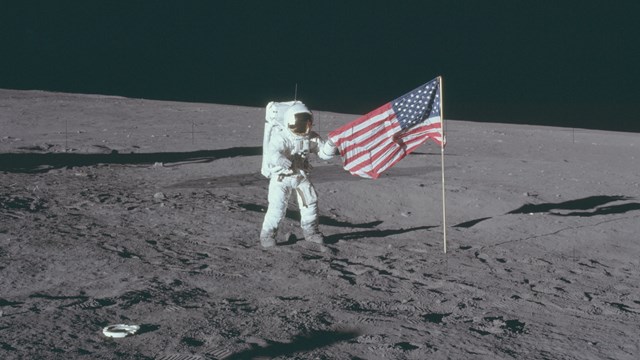 Astronaut and American flag on the surface of the moon