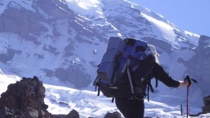 hiker with backpack in mountains with snow