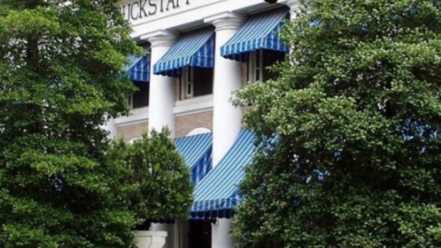 concrete building with blue striped awnings