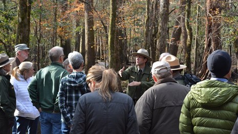 A ranger provides information to visitors outdoors 