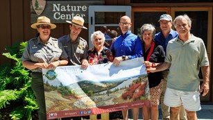 people hold up a banner in front of nature center