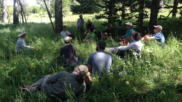 Students watch presentation from park staff outside.