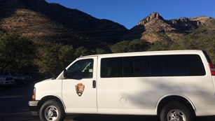 A National Park Service van with mountains in the background