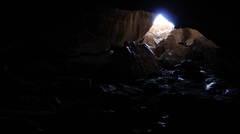 A shaft of light breaks the darkness of the cave