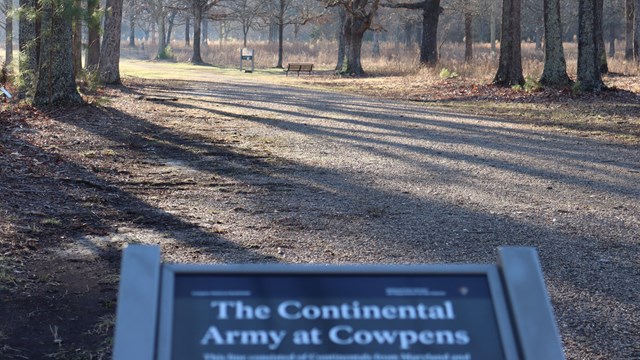 A wayside exhibit for the Continental line looking down a dirt road