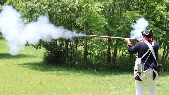 Reenactor fires a musket