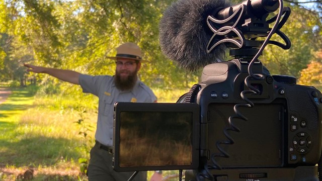 Park Ranger speaks behind camera in summer. 