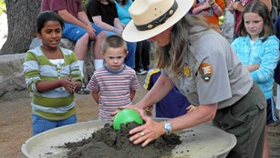 A ranger demonstrates the "collapsing volcano" activity for kids.