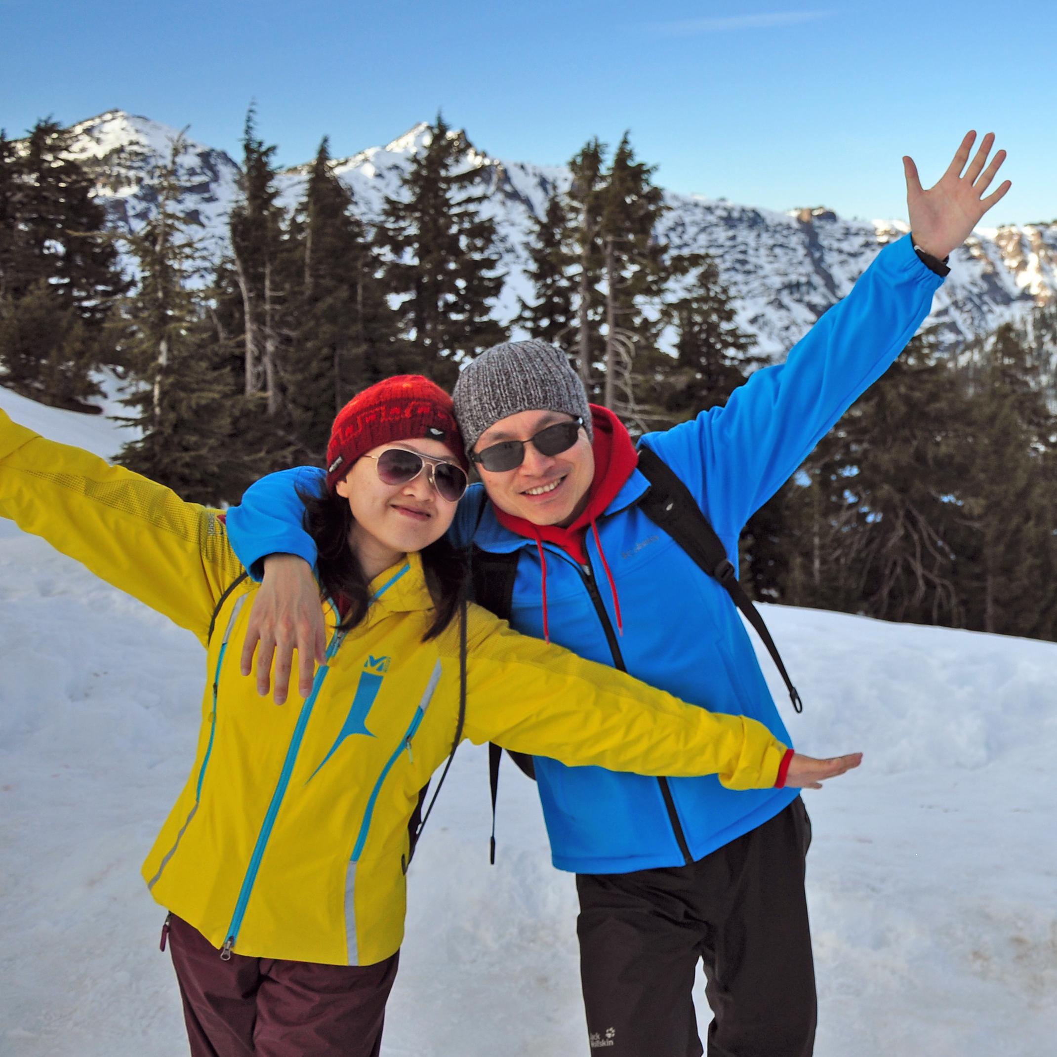 A happy couple poses in front of Crater Lake.