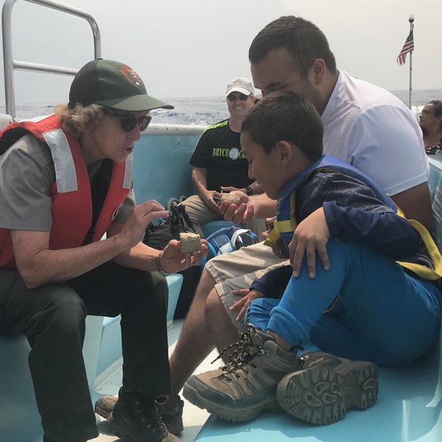 During a boat tour, ranger talks with visitors.