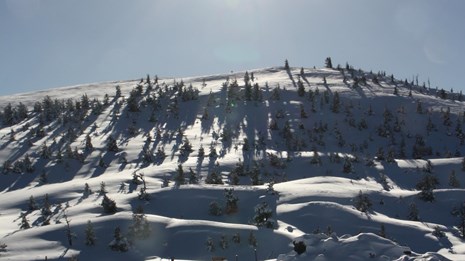 A panoramic shot of a volcanic landscape with a road running through it.