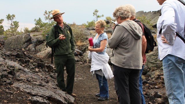 a ranger talking to a group of people on a hike
