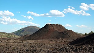 Volcanic formations rise below a blue sky.
