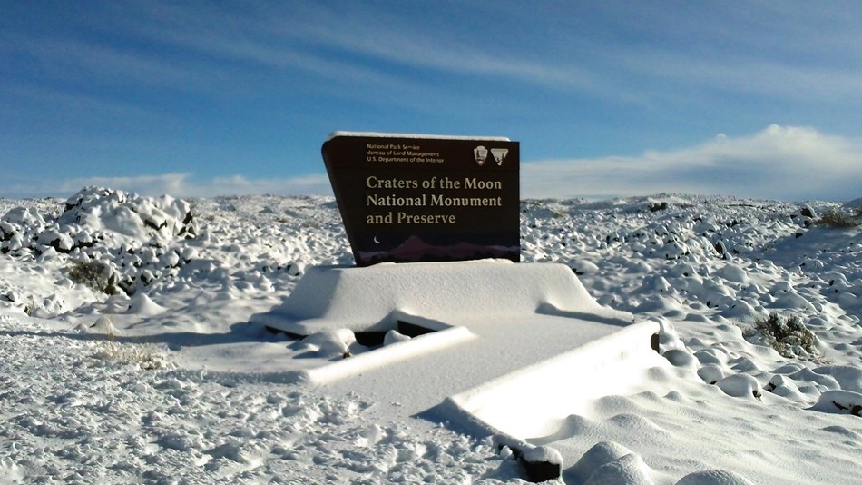 snow covered entrance sign