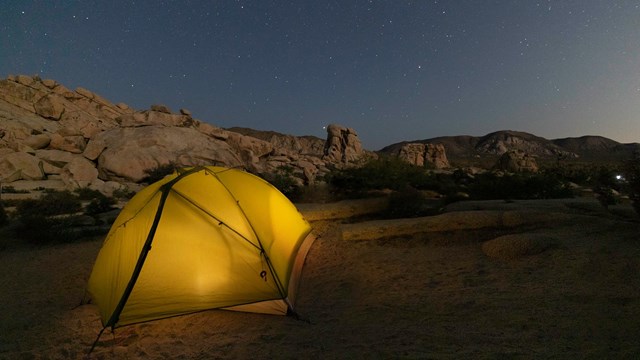 Tent in a desert with geological features 