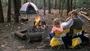 Family at a campsite with an active campfire