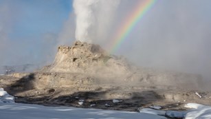 Snow-covered geyser erupting