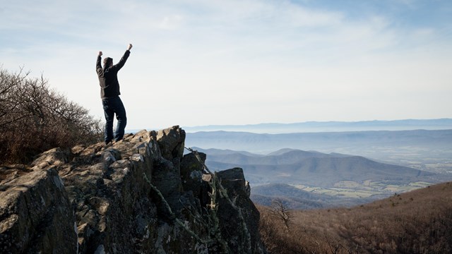 Man raising hands on mountain top