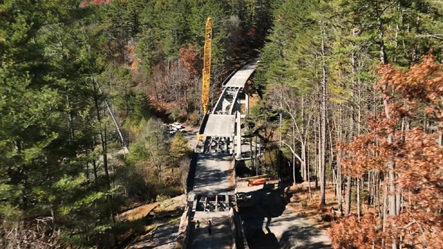 Aerial view of a crew repairing a bridge 