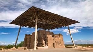 Two-story abobe house ruins underneath a large shelter structure