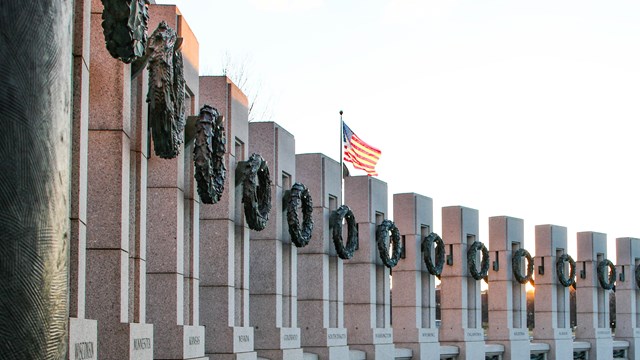 U.S. flag over memorial pillars with state names carved on them