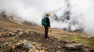Hiker on a mountainside near mist