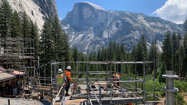 Construction crews working with a mountain in the background