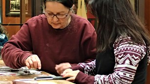 A cultural educator working with a child on an art project