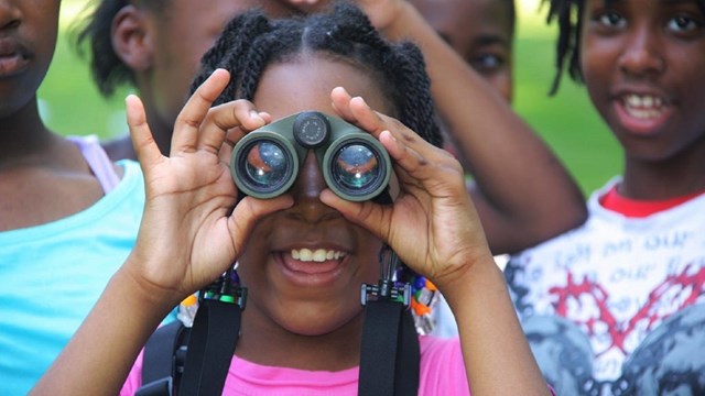 Kid looking through binoculars