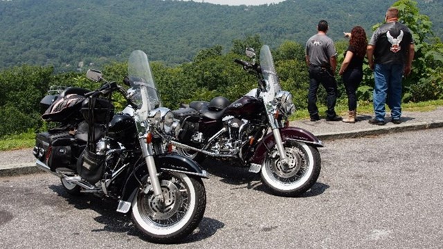 Visitors near two parked motorcycles