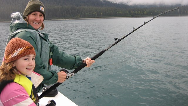 Woman and girl on a boat fishing