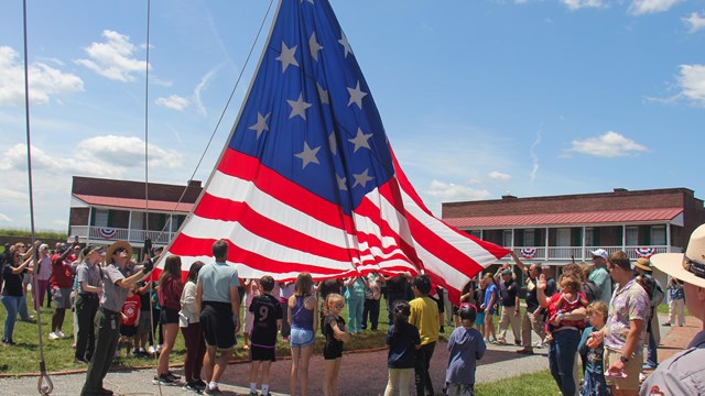Group raising a giant U.S. flag on a flagpole