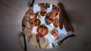 Volunteers peering down into bucket